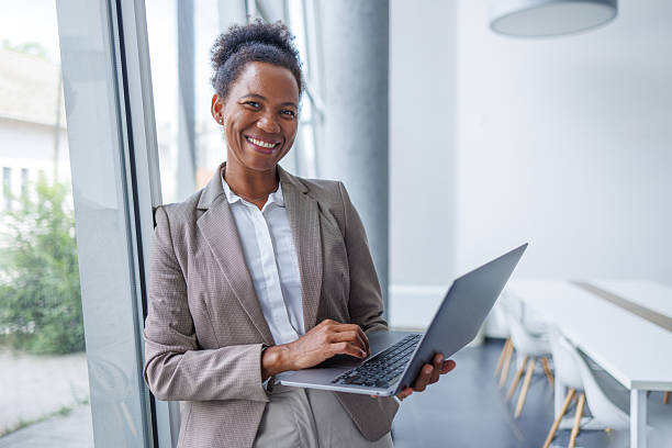 istock Smiling black businesswoman using laptop in modern office 2229747996