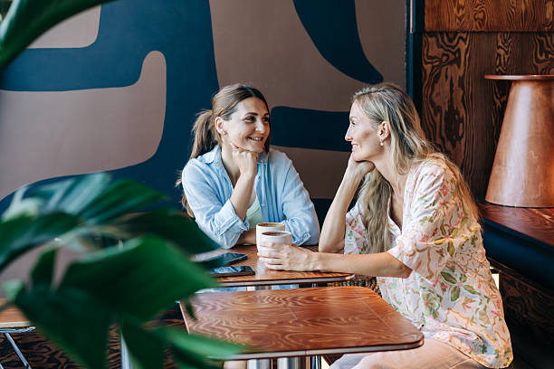 istock Two pretty caucasian women are talking while sitting in a cafe. 2229750460