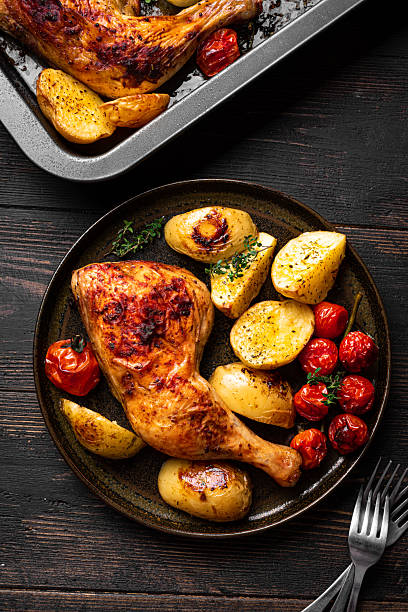 istock Oven roasted chicken leg quarter with potatoes, tomatoes 2229750707