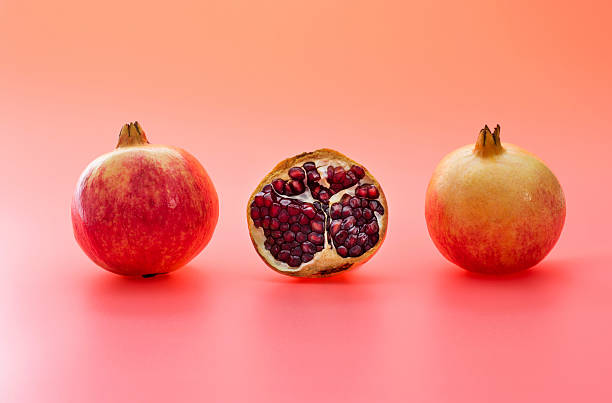 istock Two and a half pomegranates on red background 2229751509