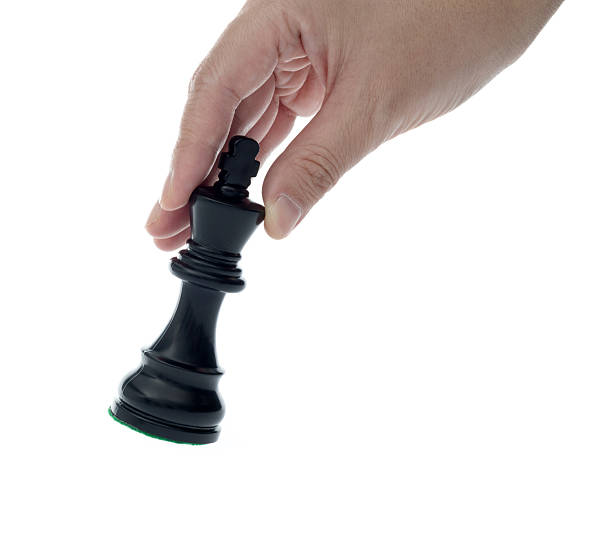 Human hand holding chess king on white background.