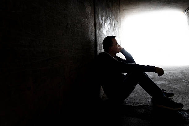 istock One man sitting in the dark tunnel 2229751984