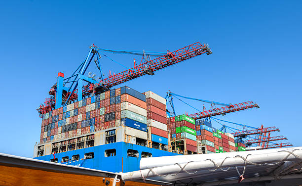 Hamburg, Germany - July 1, 2025: Busy industrial port of Hamburg with cranes and shipping containers.