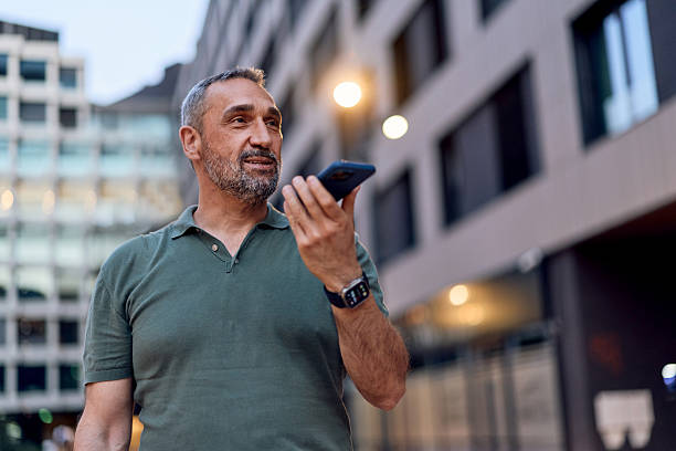 istock Mature businessman using smartphone voice assistant in urban setting 2229755322