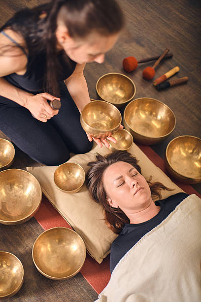 istock Young woman using singing bowls in healing session 2229757057