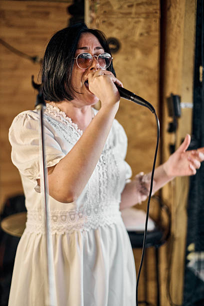 istock Enthusiastic female vocalist in rustic band rehearsal space 2229757146
