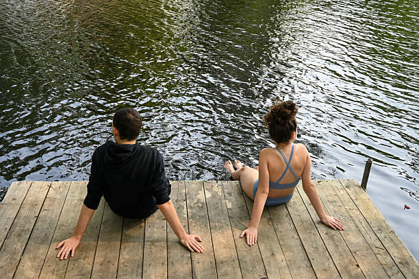 istock Two teenagers sitting at the dock on river 2229757195