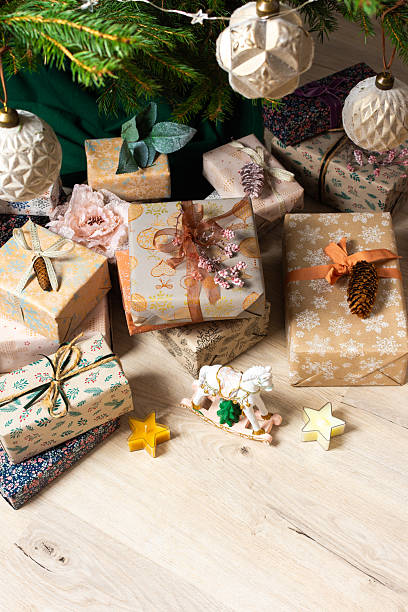 istock A cozy Christmas scene with elegant natural-toned gift boxes placed under a Christmas tree, lit with festive lights, evoking peace and seasonal joy 2229757872