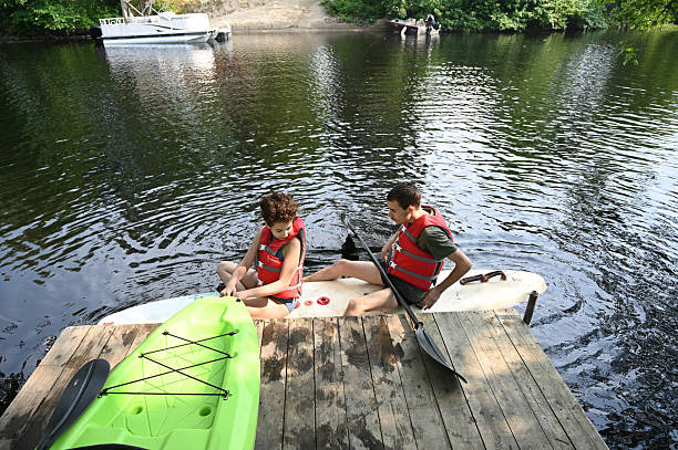 istock Two teenagers sitting on a paddleboard 2229759841