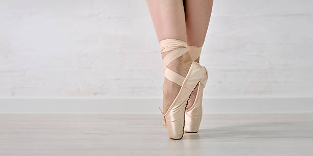 istock Ballet pointe shoes and feet on light floor 2229760270