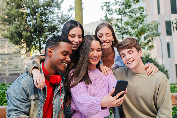 istock Joyful group of friends enjoying a fun moment together while watching something on a smartphone 2229761468