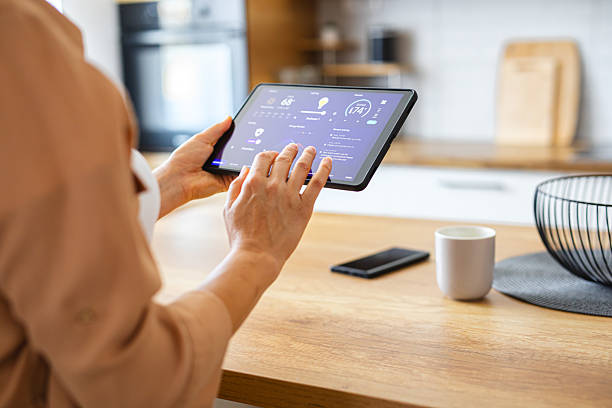 istock Woman browsing smart home control features on a tablet, including temperature, lighting, and energy statistics 2229763603