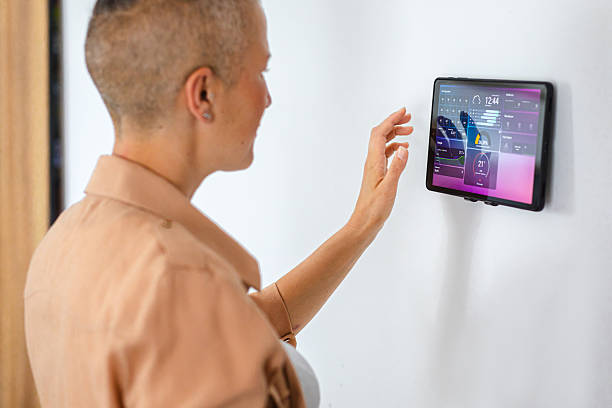istock Female homeowner managing her smart home system through a touchscreen tablet interface 2229763629