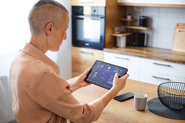 istock Woman browsing smart home control features on a tablet, including temperature, lighting, and energy statistics 2229763684