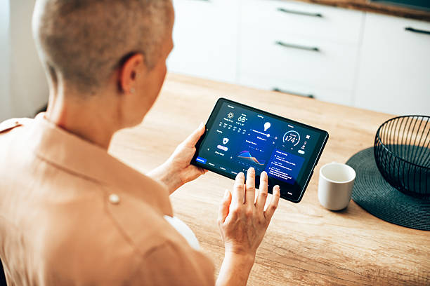 istock Woman browsing smart home control features on a tablet, including temperature, lighting, and energy statistics 2229763715