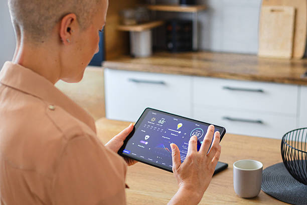 istock Woman browsing smart home control features on a tablet, including temperature, lighting, and energy statistics 2229763735