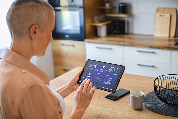 istock Woman browsing smart home control features on a tablet, including temperature, lighting, and energy statistics 2229763756