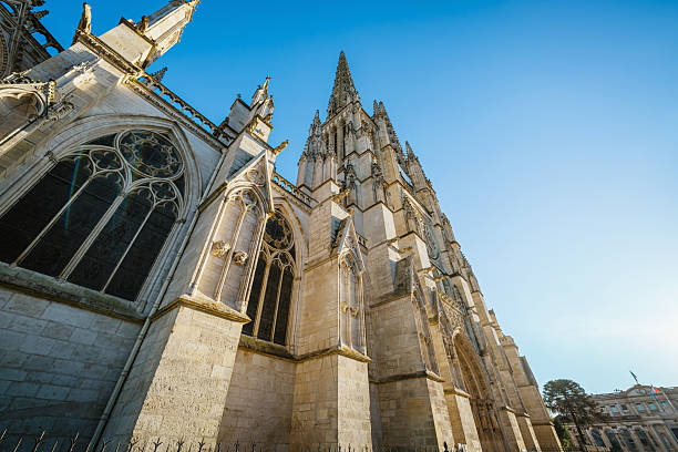 View of a historic Gothic cathedral in Bordeaux, France with intricate architecture and bright sunlight creating a beautiful play of light and shadow, representing French heritage, religion, and inspiring design.