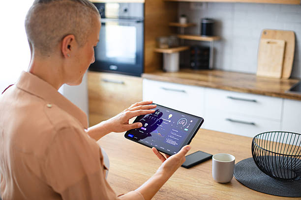 istock Woman browsing smart home control features on a tablet, including temperature, lighting, and energy statistics 2229763823