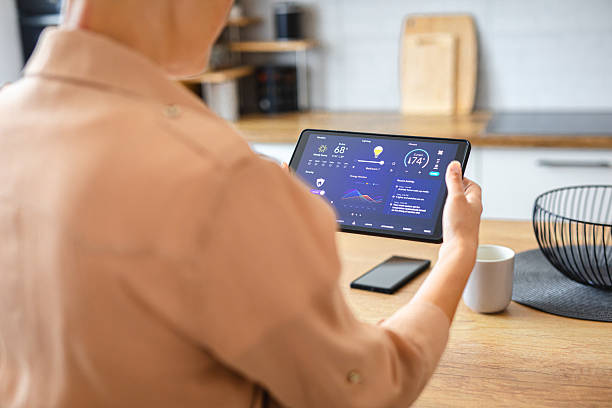 istock Woman browsing smart home control features on a tablet, including temperature, lighting, and energy statistics 2229763842