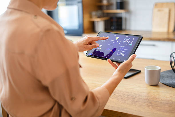 istock Woman browsing smart home control features on a tablet, including temperature, lighting, and energy statistics 2229763884