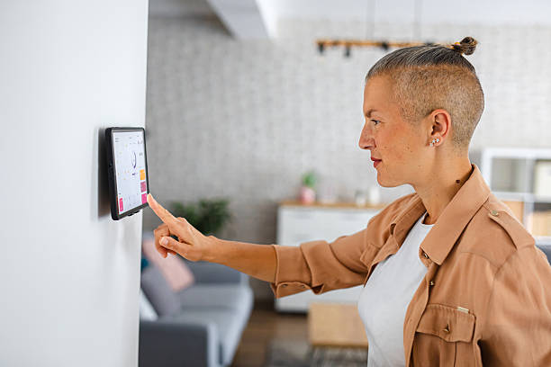 istock Woman browsing smart home control features on a tablet, including temperature, lighting, and energy statistics 2229764037