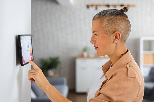 istock Woman browsing smart home control features on a tablet, including temperature, lighting, and energy statistics 2229764086