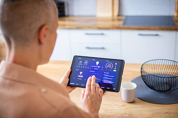 istock Woman browsing smart home control features on a tablet, including temperature, lighting, and energy statistics 2229764130