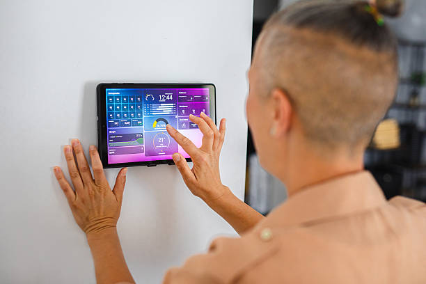istock Woman browsing smart home control features on a tablet, including temperature, lighting, and energy statistics 2229764142