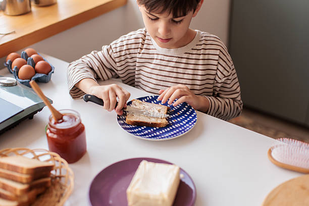 istock Young Boy Making Sweet Sandwich for Breakfast 2229764311
