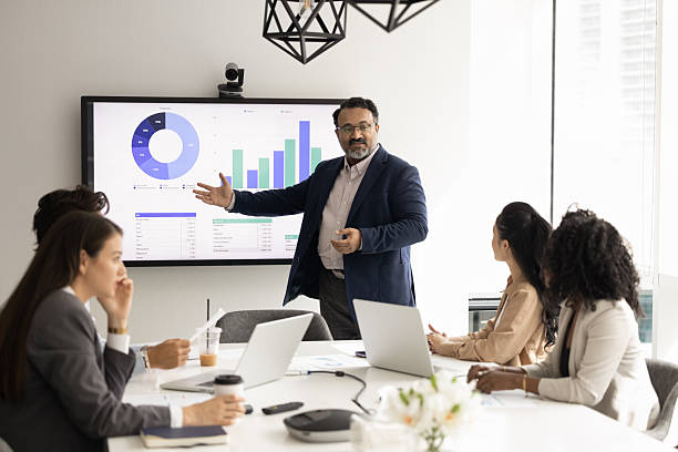 istock Mature business leader present statistic on screen to young managers 2229766634