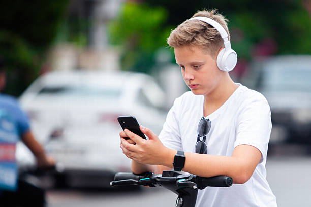 istock Teen Boy Checking Time While Riding Scooter to School 2229767408