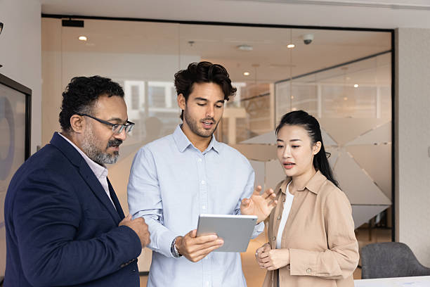 istock Diverse multiracial businesspeople group standing in office using tablet pc 2229769485