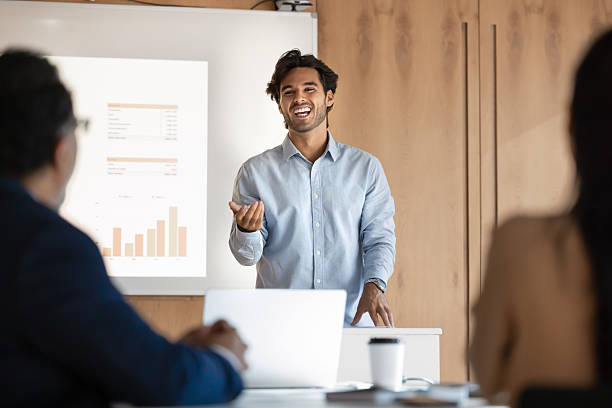 istock Cheerful young businessman present project at conference with confidence humor 2229771124