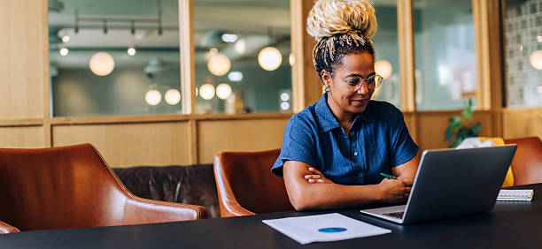 istock Young woman working on a laptop in a stylish office environment 2229778261