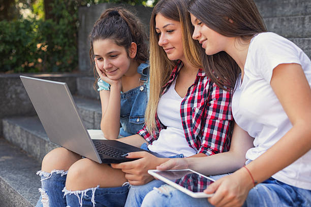 istock Three young students are sitting on the stairs on the campus, using laptop and preparing for classes 2229780506