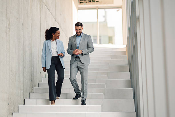 istock Businesspeople walking and talking on stairs in modern office 2229782531