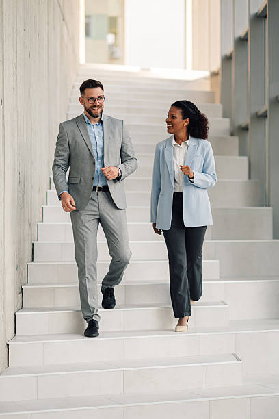 istock Businesspeople walking and talking on stairs in modern office 2229782541