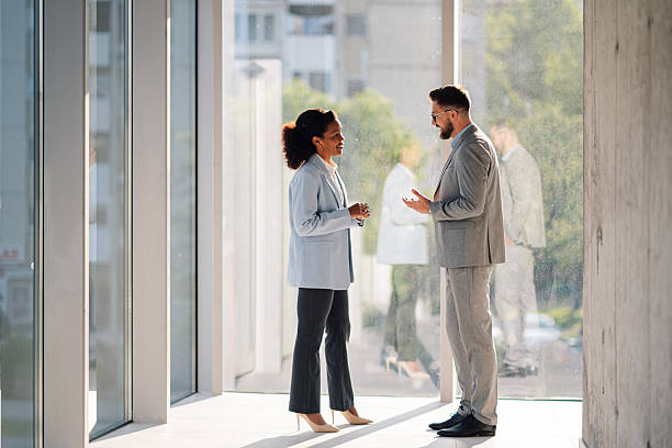 istock Businesspeople discussing near window in modern office 2229782677