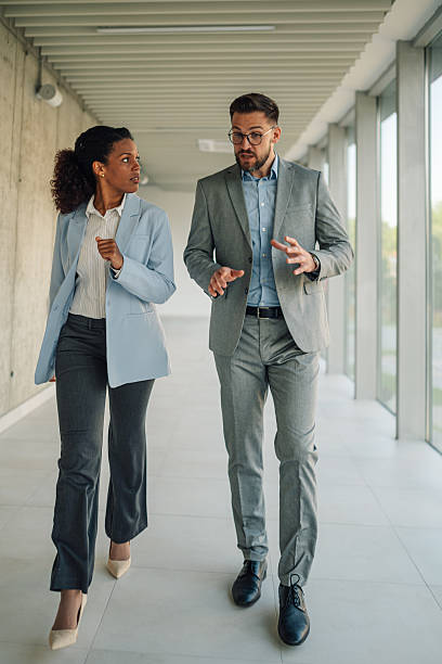 istock Businesspeople walking and talking in office hallway 2229782948