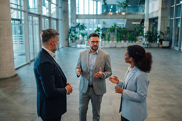 istock Business people talking in modern office building lobby 2229783261