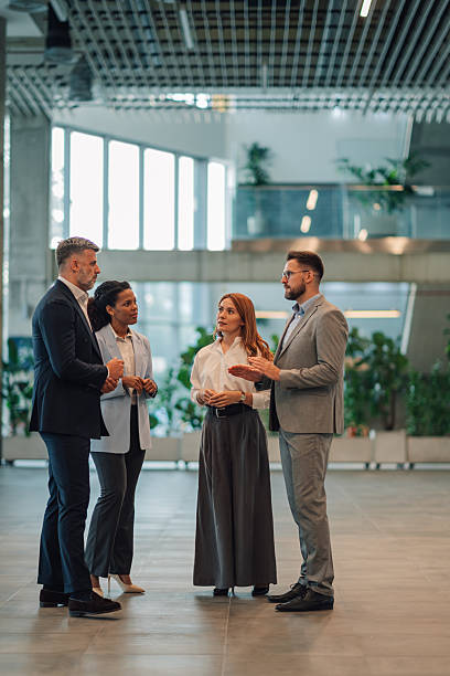 istock Business people talking in modern office building lobby 2229783369