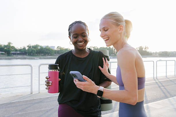 istock Two women sharing a moment outdoors in workout attire near a waterfront 2229783851