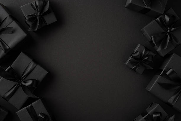 istock Minimalist arrangement of black gift boxes with silk ribbons framed on a dark surface 2229790849