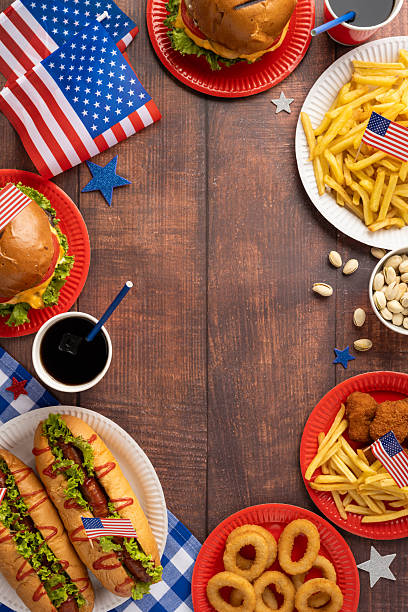 istock Labor Day and Independence Day vertical picnic celebration concept featuring classic American foods like hamburgers, hot dogs, and fries with decorative flags on a rustic wooden table 2229790973