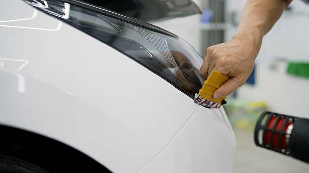 istock Professional applying protective film on car headlight 2229791254