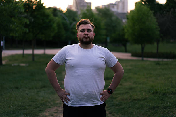 Portrait of determined overweight man taking a break after exercising in a city park