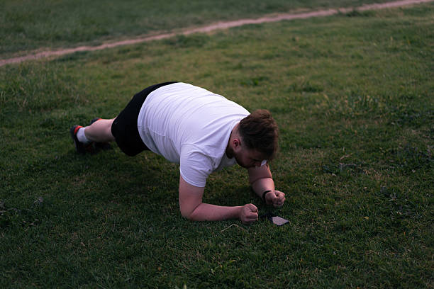 istock Overweight man doing plank exercise in a city park 2229792345