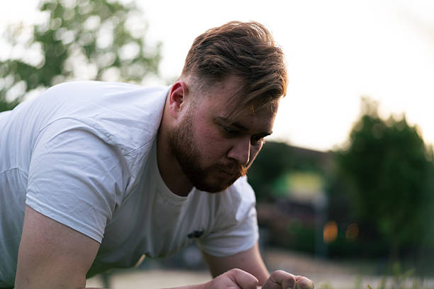 Determined man exercising outdoors, focusing on improving fitness and well-being