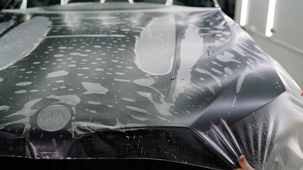 istock Professional applying protective film on car hood 2229792546
